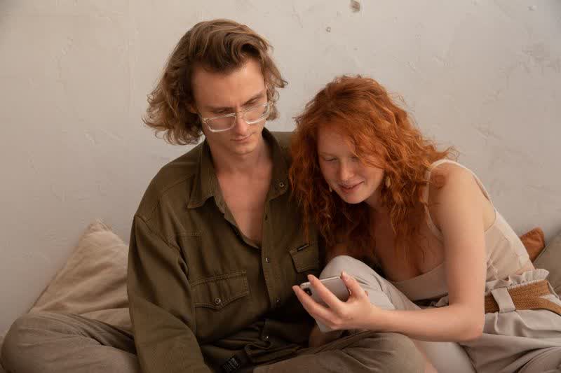 A couple considering something together on a phone screen