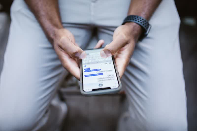 Hands typing a text message on a smartphone